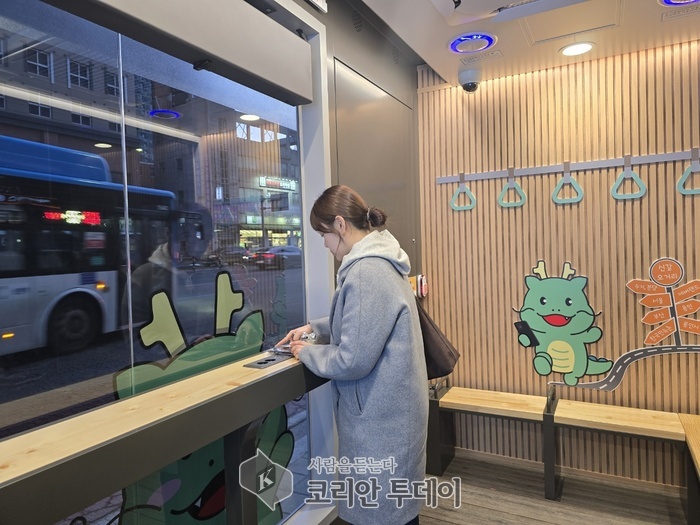 [코리안투데이] 한 시민이 신갈오거리에 새로 설치한 '스마트 버스 쉼터' 안에서 휴대폰을 충전하고 있는 모습 © 김나연 기자