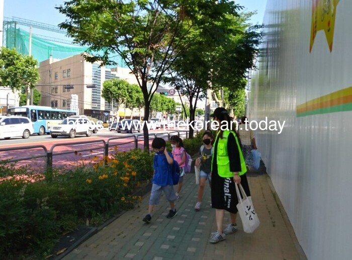 [코리안투데이] 사진 구로구 언론팀 제공 어린이들이 교통안전지도사와 함께 등교하고 있다. © 박수진 기자