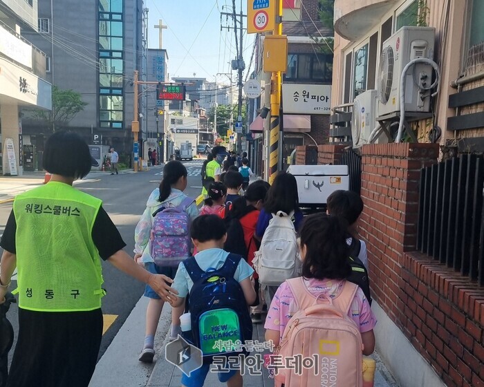 [코리안투데이] 성동구 워킹스쿨버스 교통안전지도사가 아이들의 등하굣길 동행 모습 © 손현주 기자