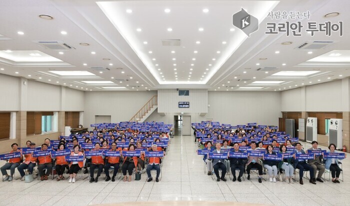 [코리안투데이] (사진) 행사 참석자들이 자원봉사 구호가 적힌 현수막을 들고 다같이 기념 촬영을 하고 있다. © 박수진 기자