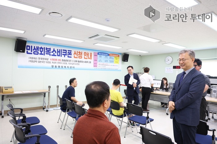 [코리안투데이] (사진1) 항동주민센터를 찾아 ‘민생회복 소비쿠폰’ 1차 신청 현장을 점검하고 주민들과 대화하고 있다.© 박수진 기자