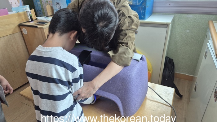 [코리안투데이] (사진) 한 교사가 손 위생 교육 장비(뷰박스)를 활용해 어린이의 손 씻기 상태를 확인하고 있다. © 박수진 기자