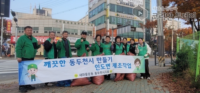 Saemaeul Männer- a Fraleeder vu Saengyeon 2-dong maachen Onkrautjäten fir e méi schéint Duerf