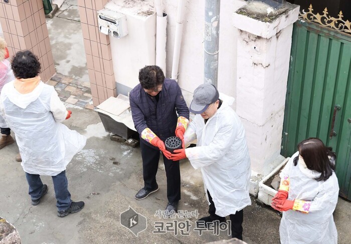 [코리안투데이] 사랑의 연탄 나눔 봉사활동을 하고 있는 모습(최충규 대덕구청장이 손외수 플랜트치과 대표원장에게 연탄을 전달하고 있다.) © 임승탁 기자