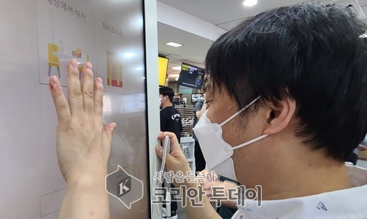 [코리안투데이] 시각장애인권리보장연대의 '내돈내산 권리찾기 캠페인' 모습. 한 시각장애인이 키오스크를 클릭해 주문하려 했지만 실패했다.(사진=에이블뉴스) © 변아롱 기자