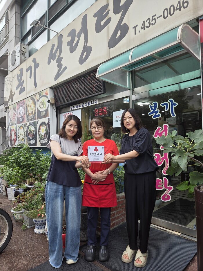 Các hội viên Hội tự quản tổ trưởng phường Namchon-dorim-dong đang chỉnh trang miệng thu nước mưa trong mưa.