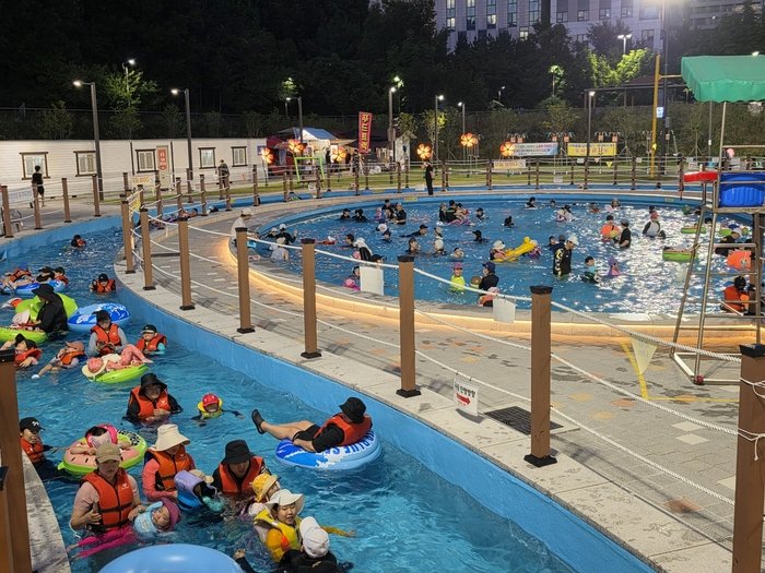 南洞ムルビッ遊び場の流水プールで水遊びをする家族連れの来場者